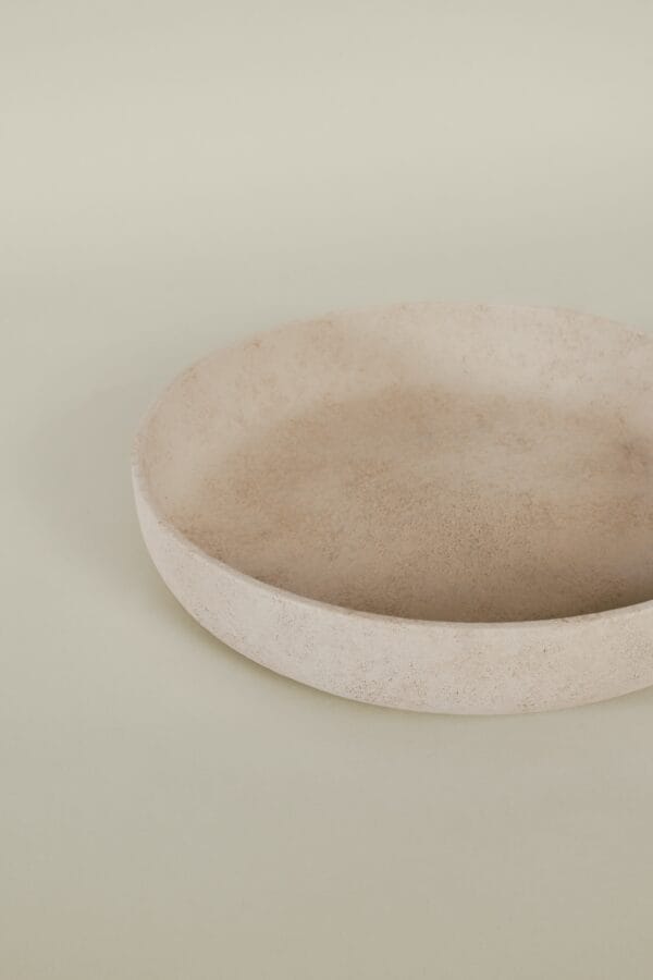 Minimalist beige Bola bowl with a textured finish, displayed on a neutral background.