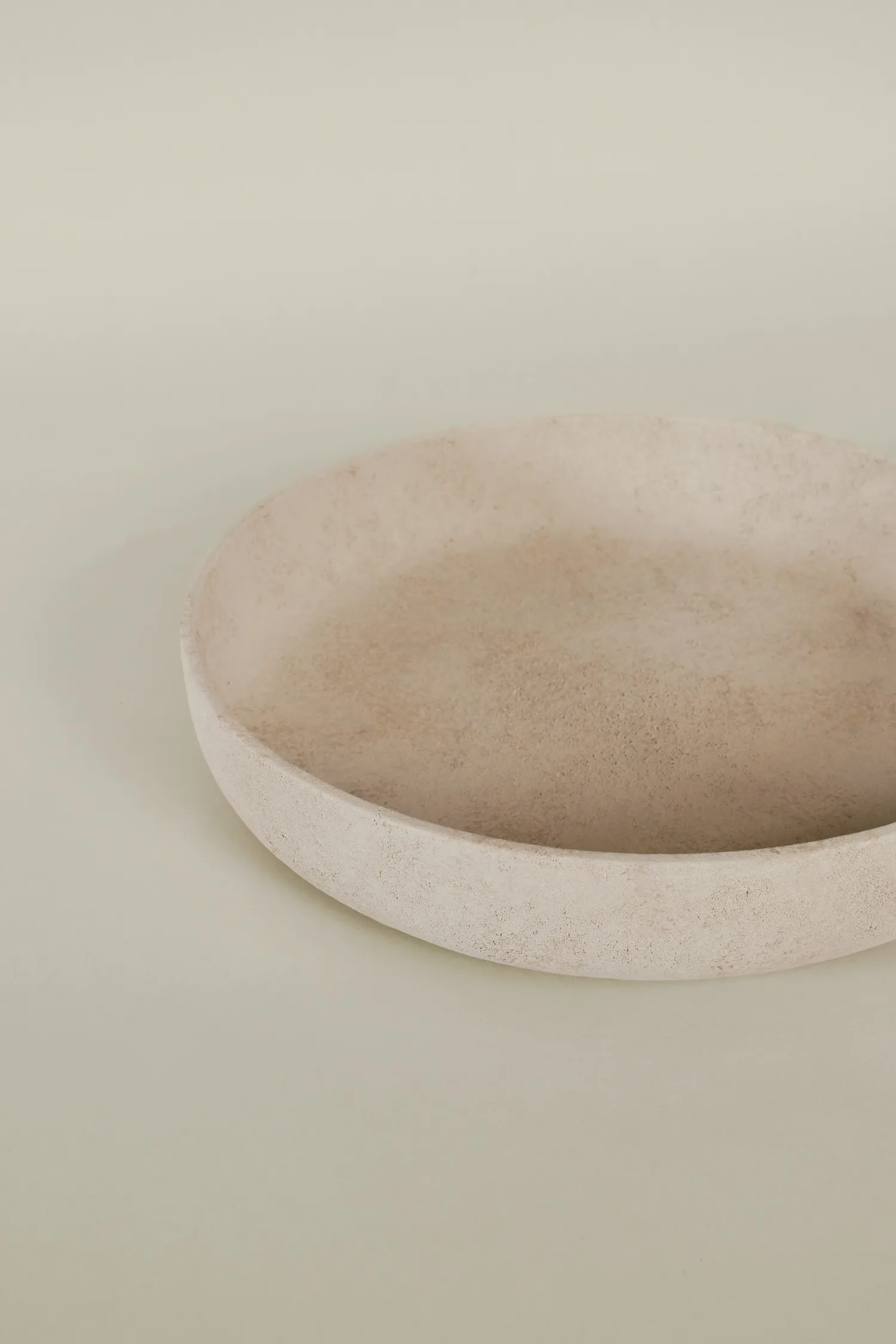 Minimalist beige Bola bowl with a textured finish, displayed on a neutral background.