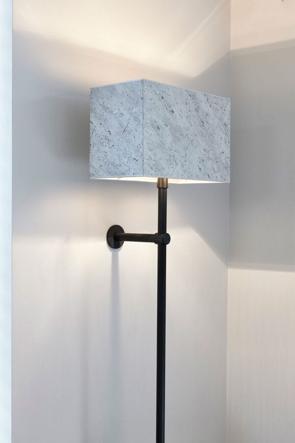Archiflex wall light with a large rectangular marble-textured shade and slim black arm.