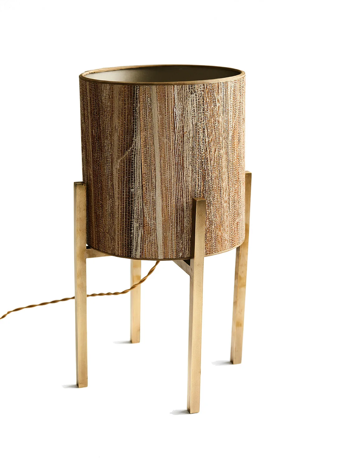 Close-up of the Cato table lamp with a wood-textured cylindrical shade and brushed bronze metal legs.