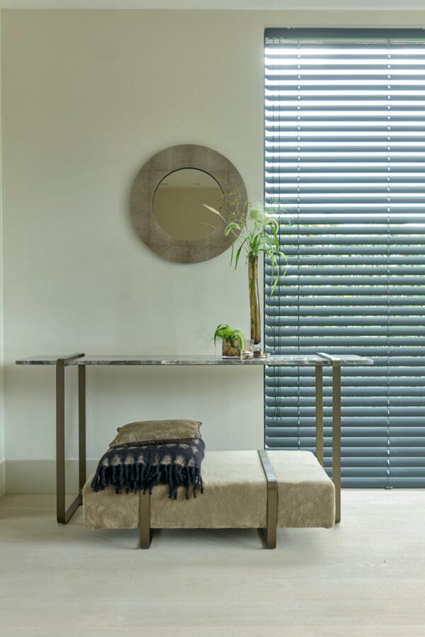 DuMonde mirror above a marble console table with decorative plants in a softly lit interior.