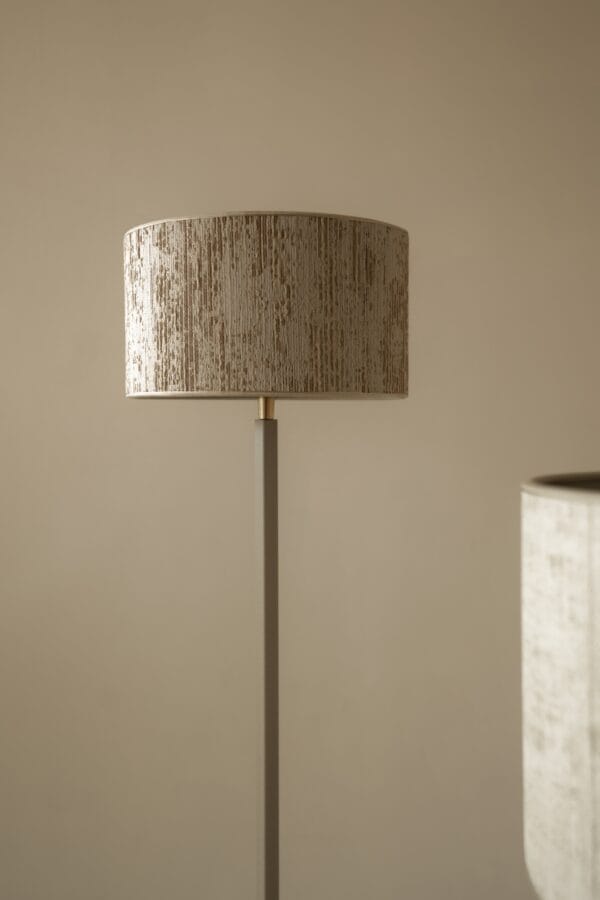 Close-up of Duld floor lamp with cylindrical textured lampshade and minimal pole design.