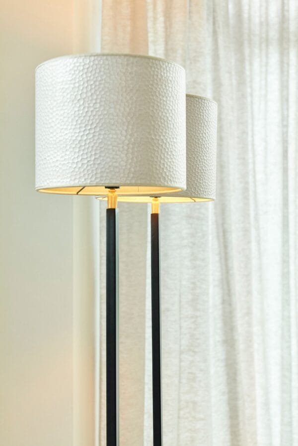 Close-up of Duld lamp shades with white hammered texture, softly lit from inside.