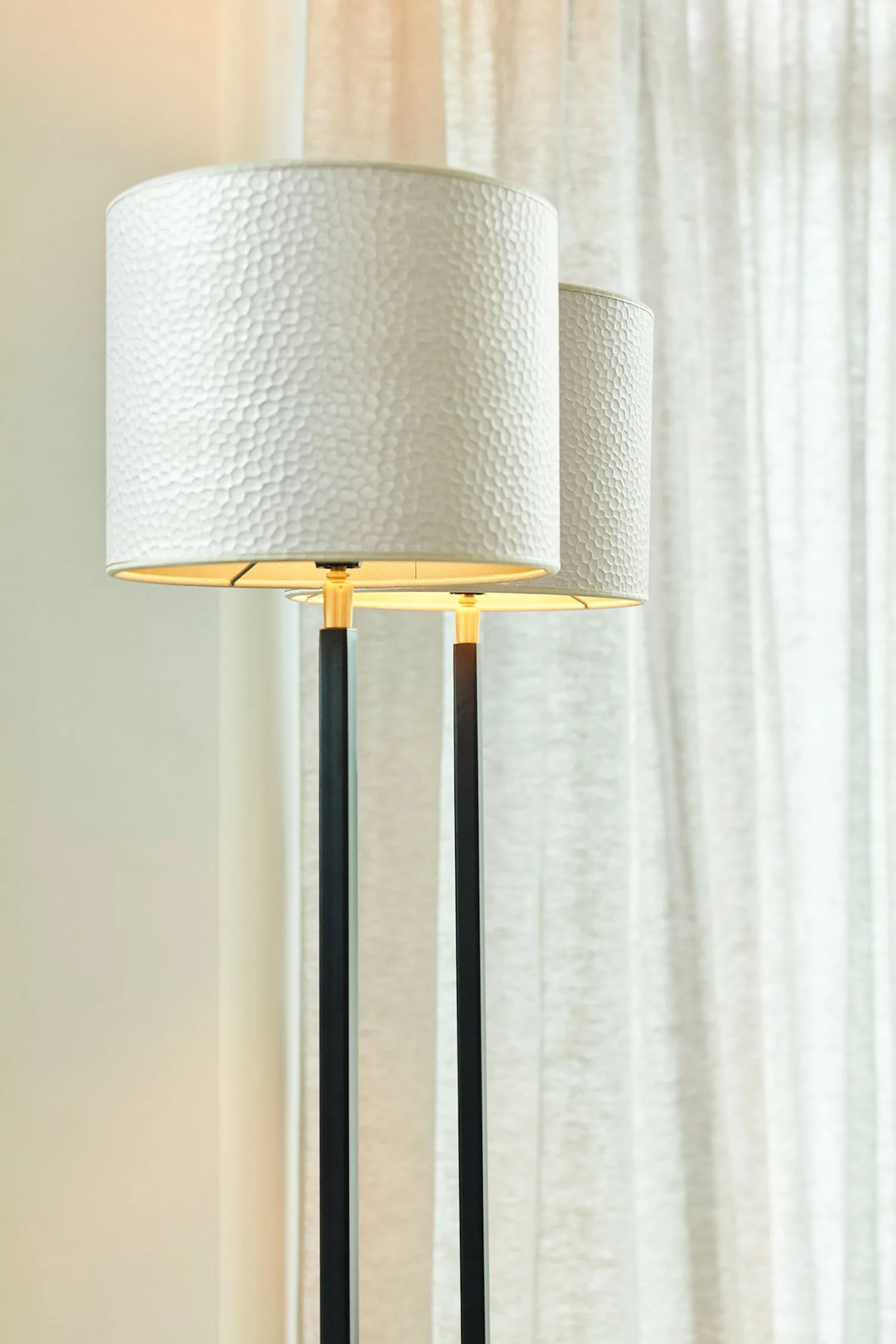 Close-up of Duld lamp shades with white hammered texture, softly lit from inside.