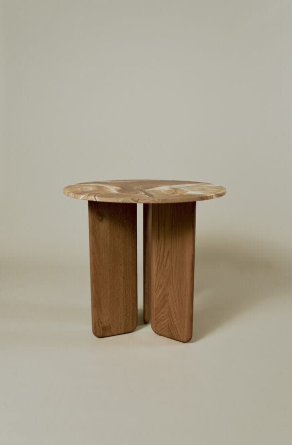 Emilia dining table with a swirling patterned wooden top and three-leg base in natural wood finish.