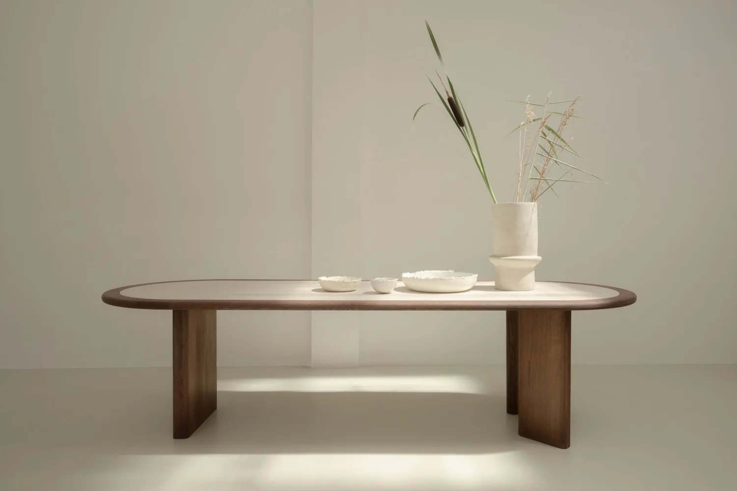 Front view of the Hudson dining table featuring a light tabletop with dark wooden frame and legs.