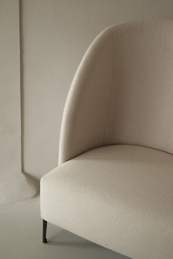 Close-up of the Hugo chair's curved backrest and fabric texture.