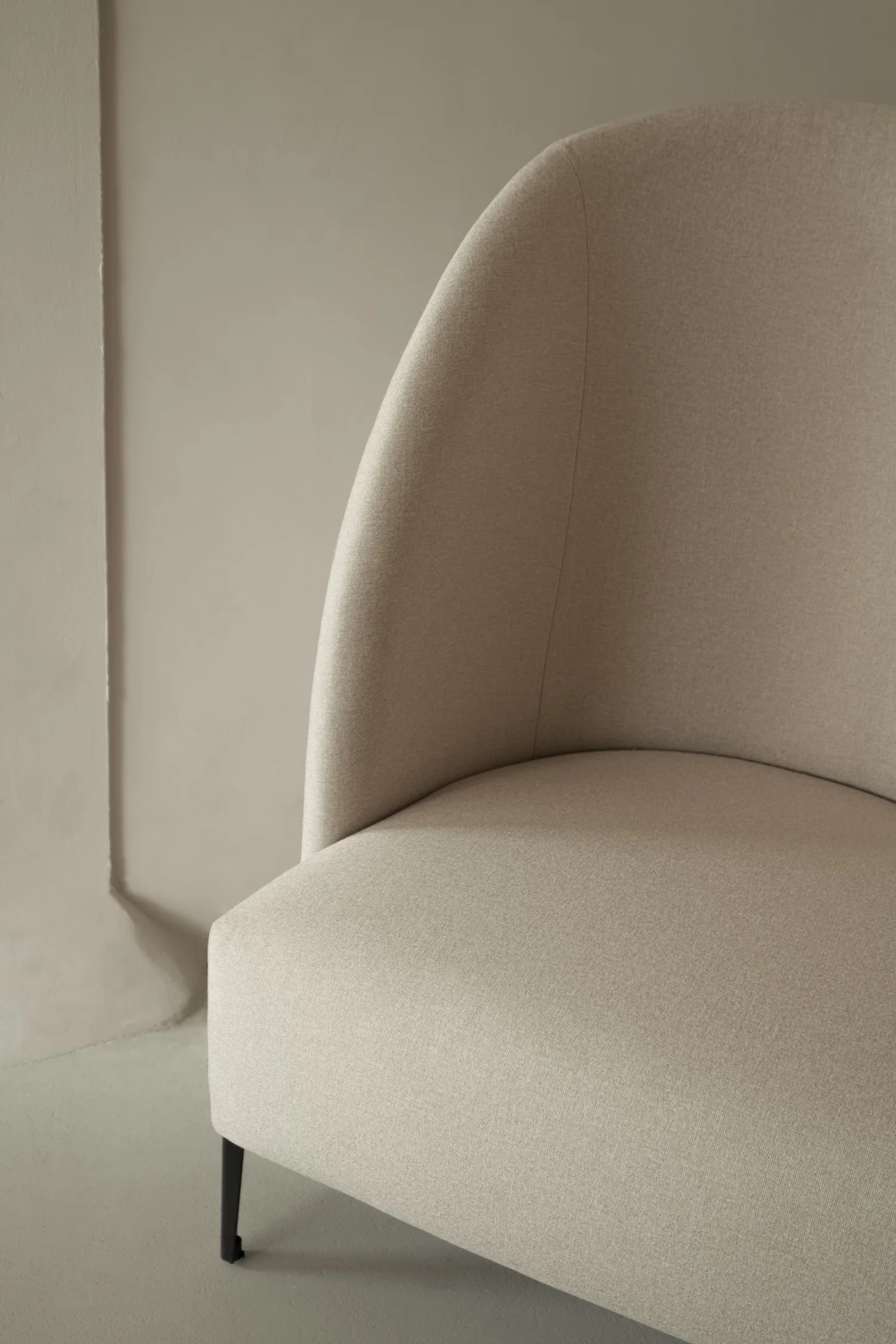Close-up of the Hugo chair's curved backrest and fabric texture.
