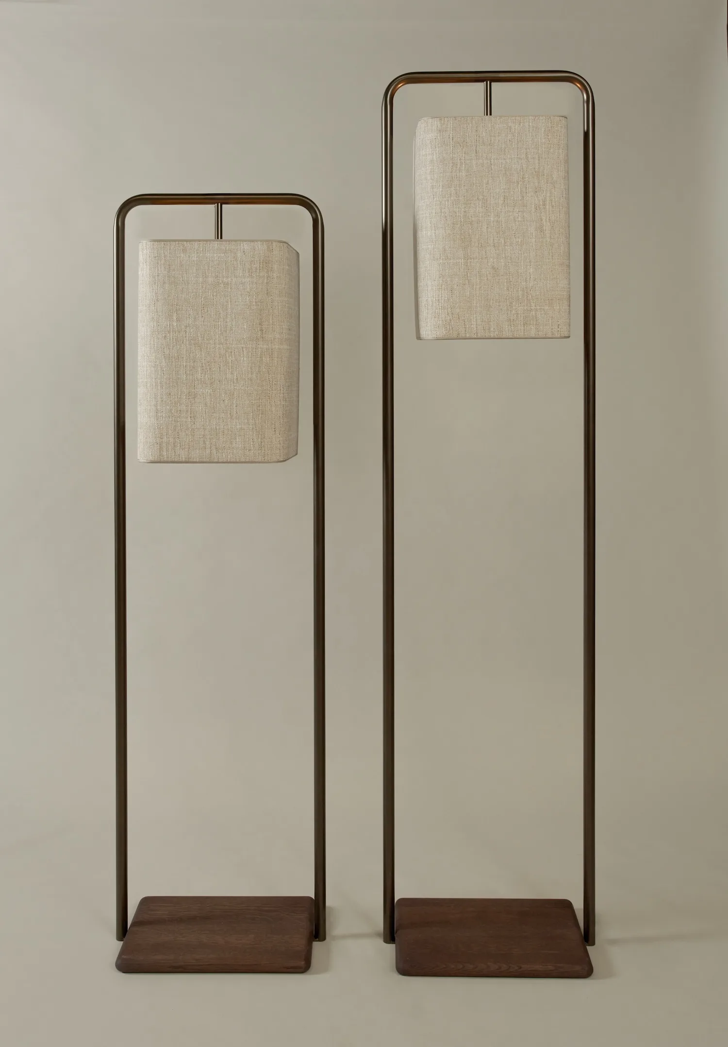 Two Lora floor lamps in bronze metal with beige rectangular shades and dark wood bases.