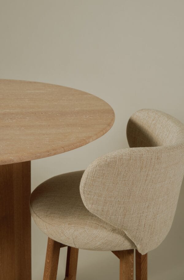 Detailed view of the Margaux barstool’s curved back and round table edge.