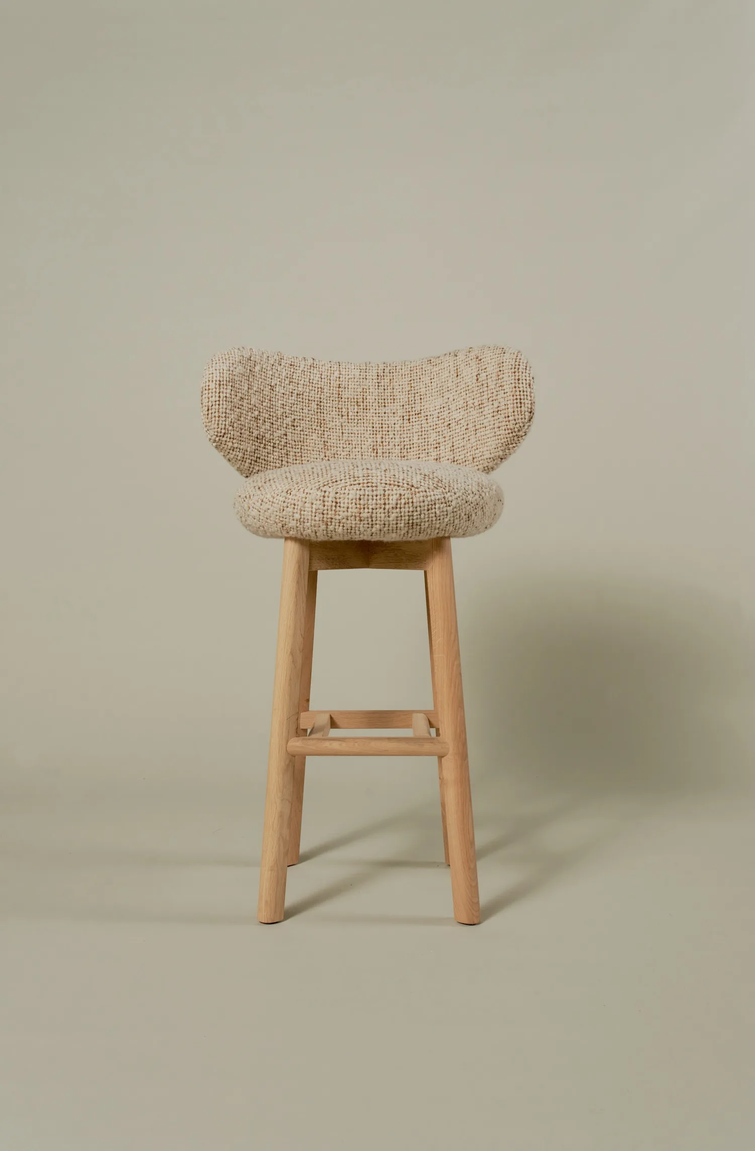 Margaux barstool upholstered in boucle fabric with light oak legs, front view.