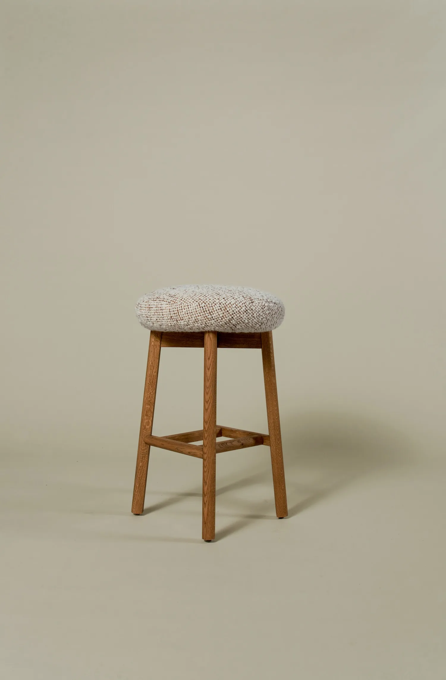 Margaux barstool featuring a rounded boucle seat and warm oak frame.