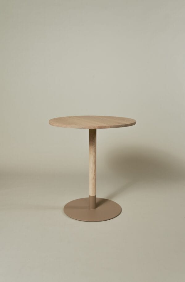 Maxime bistro table featuring a round light oak wooden top with minimalist central leg and base.