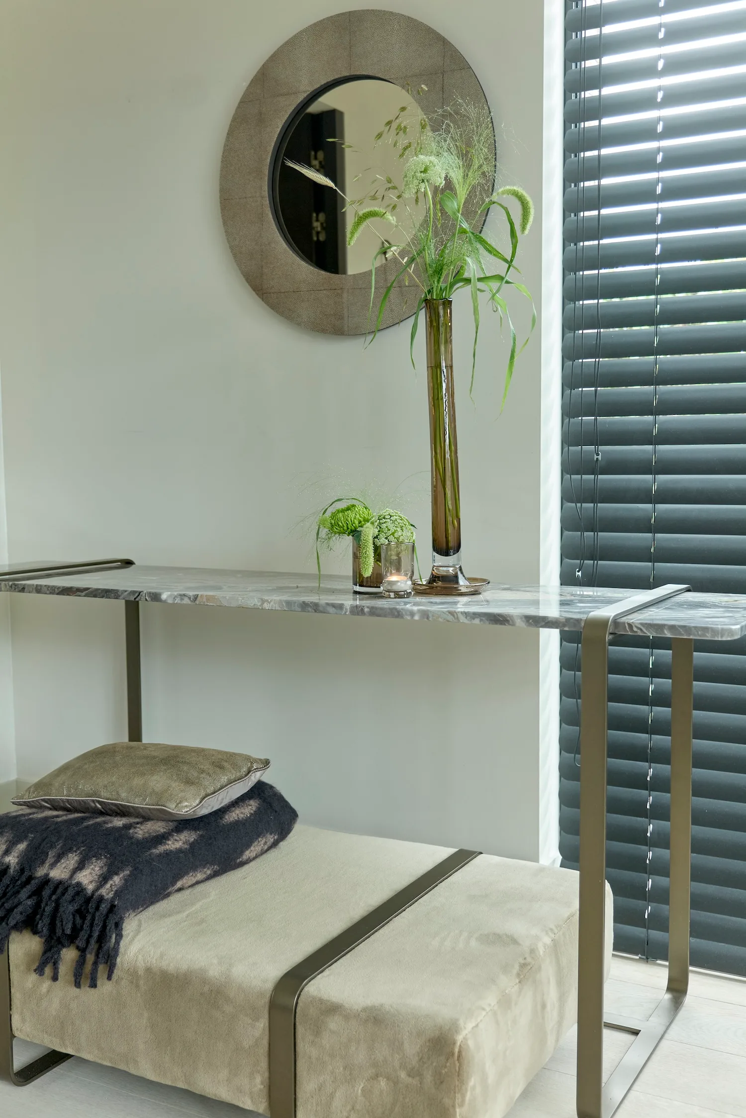 Close-up of Monaco console showing marble detail, decorative objects, and upholstered bench below.