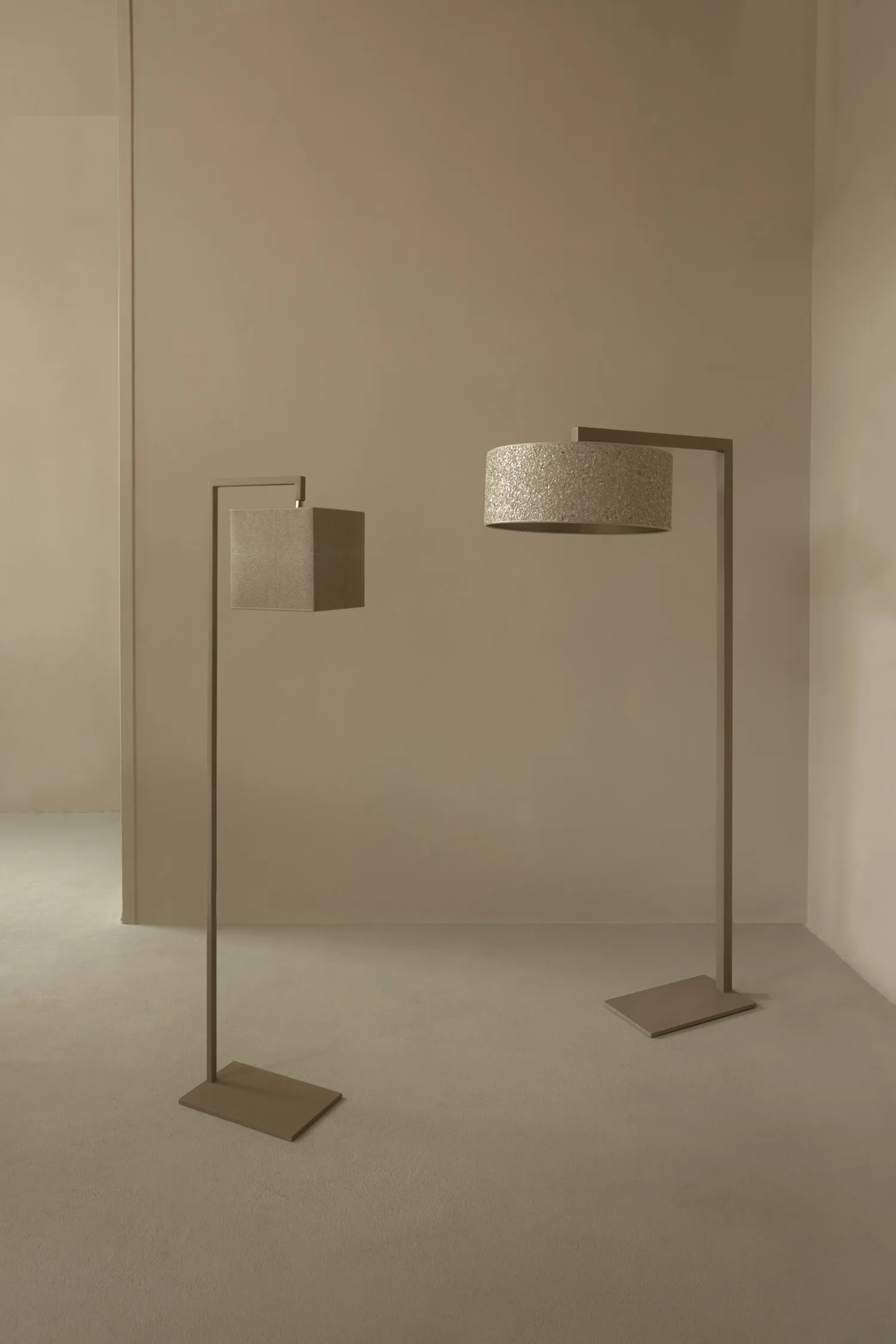 Two Murillo floor lamps in a neutral-toned setting, featuring minimalist square and round fabric shades on angular metal frames.