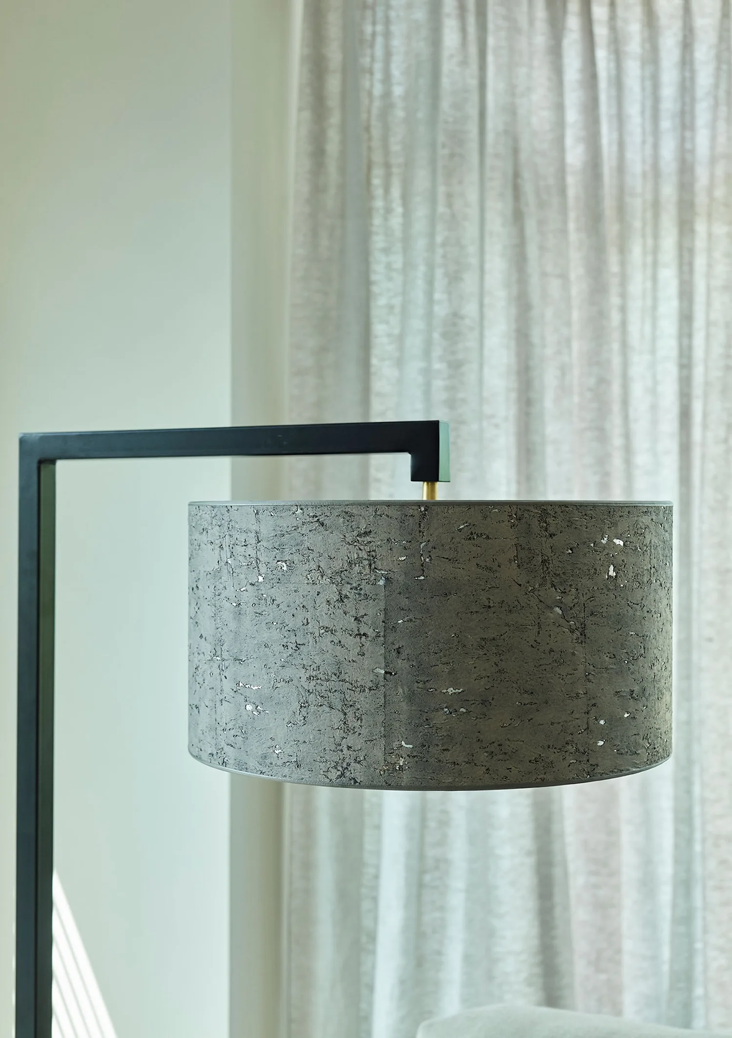 Close-up of the Murillo lamp’s grey textured drum shade suspended from a matte black frame.