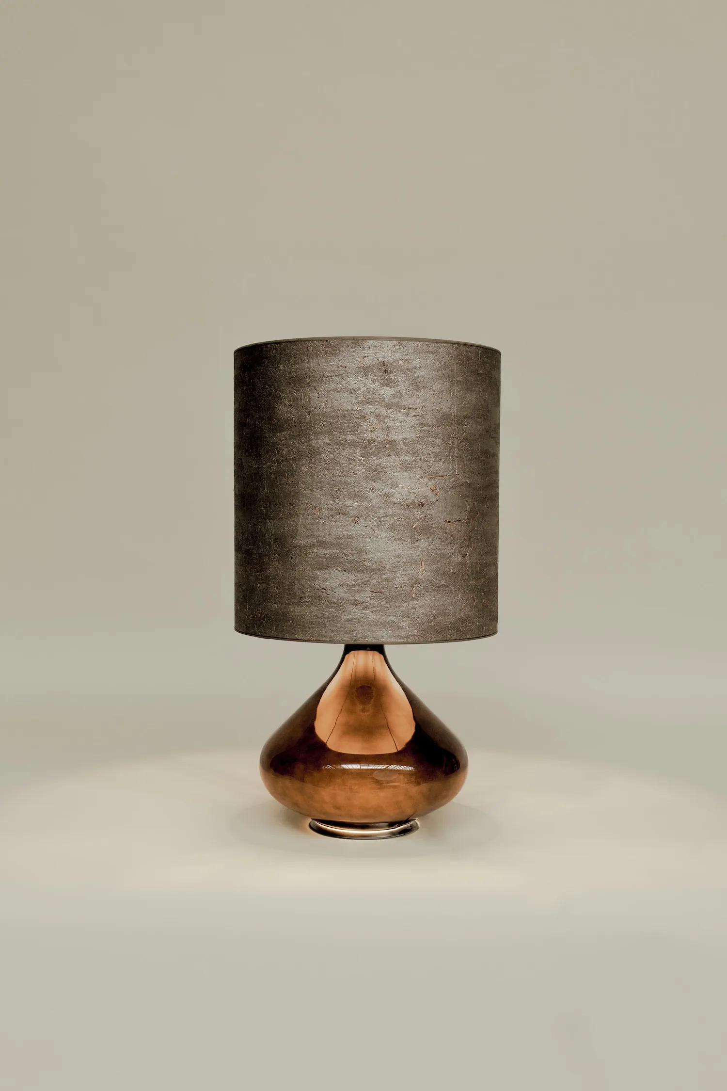 Paula table lamp with dark bronze base and textured black cylindrical shade on neutral background.