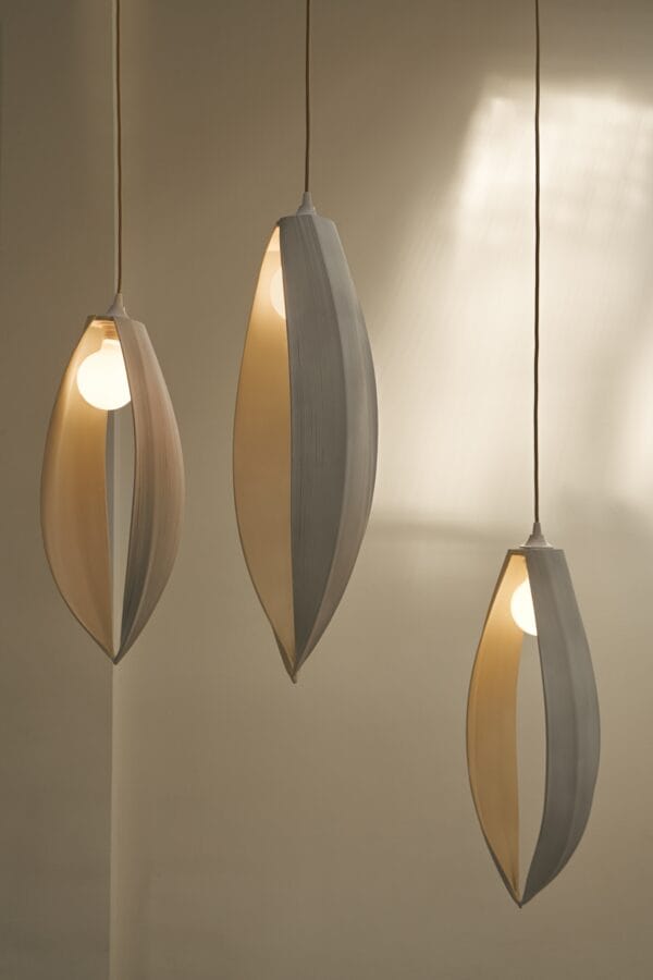 Trio of Petal ceiling lights with organic, sculptural wooden forms hanging in a softly lit interior.
