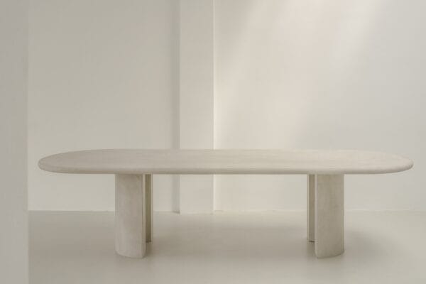 Minimalist Seine dining table in a bright setting, showing its full oval top and curved legs.