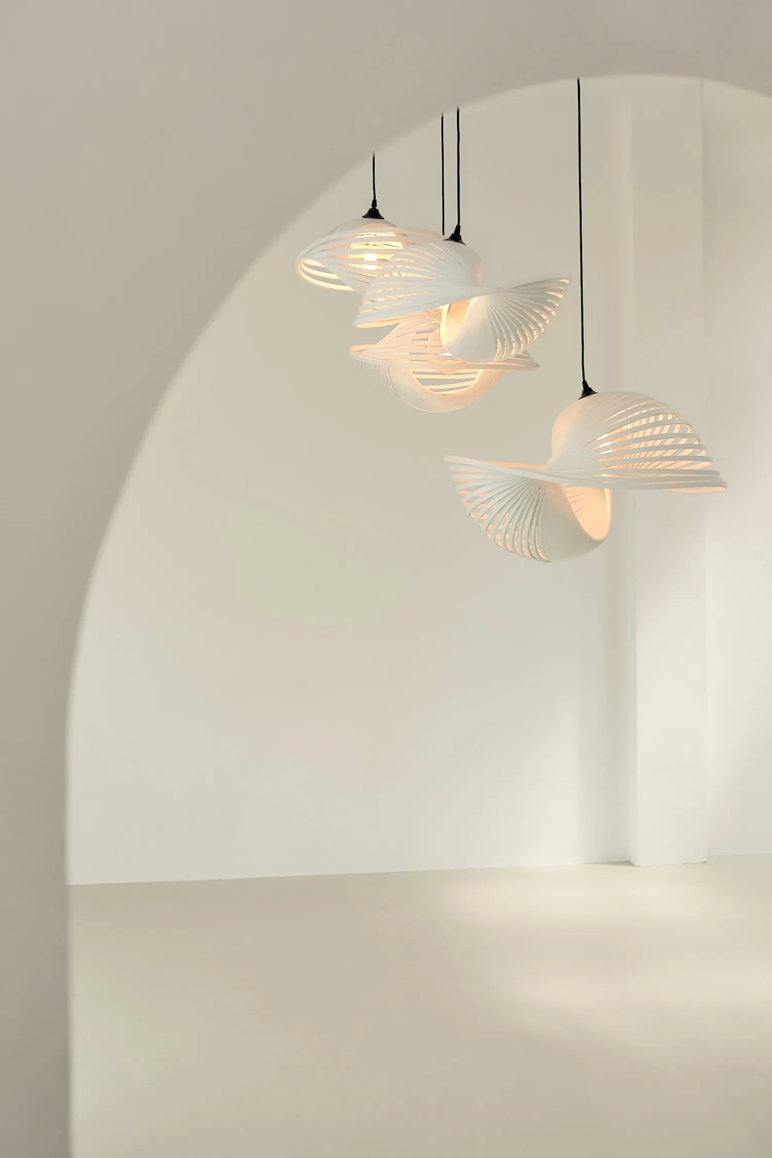 Set of three Valbonne Air lights suspended in a minimal interior, radiating soft ambient light.