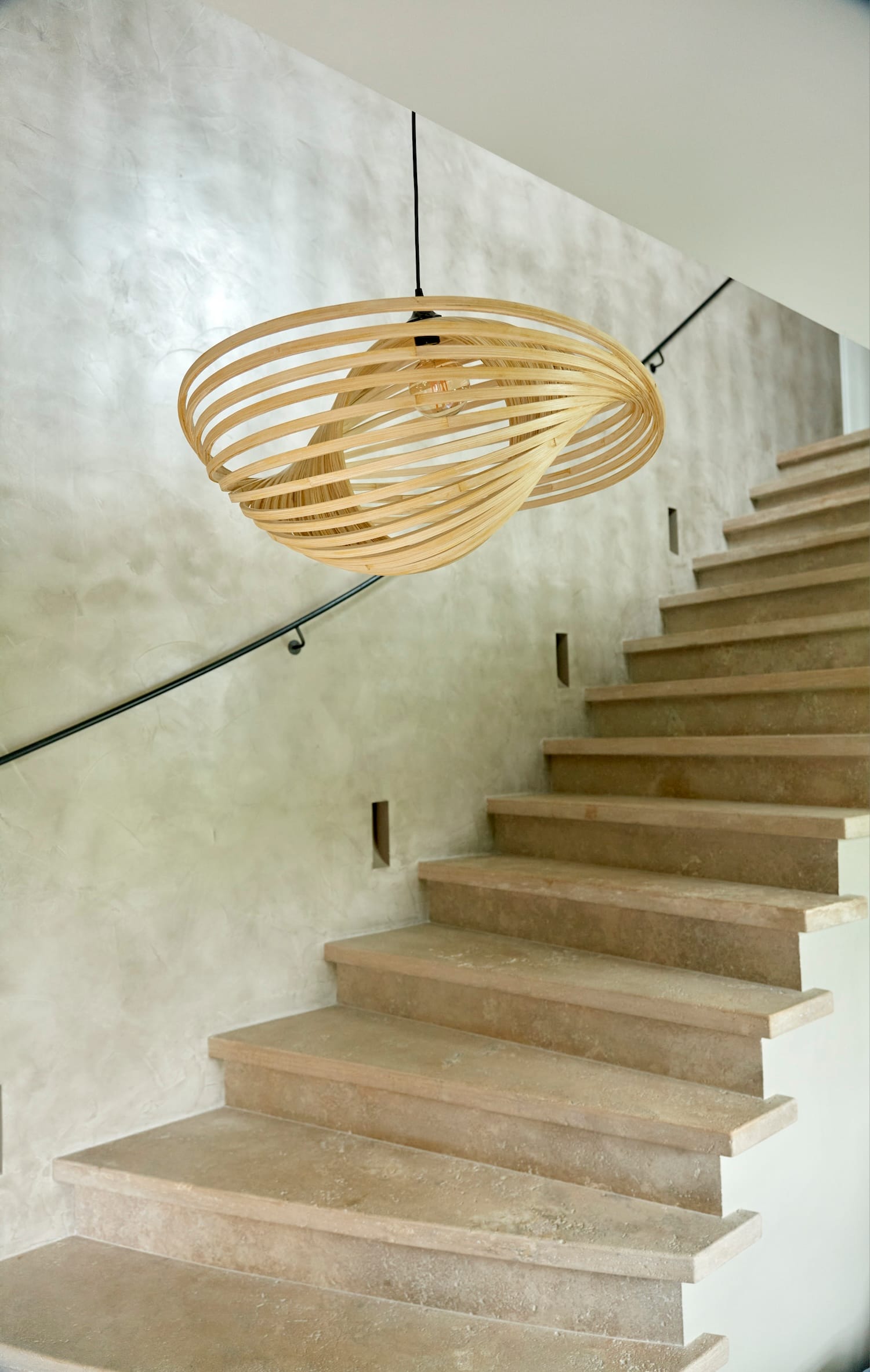 Single Valbonne Air ceiling light in natural wood finish hanging above a staircase.