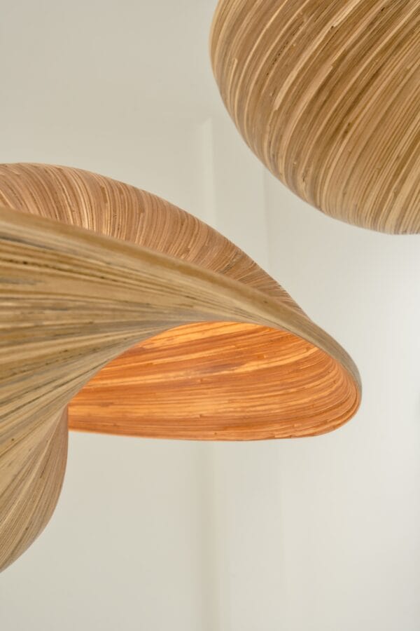 Close-up of a Valbonne ceiling light showing its sculptural, twisted wooden design with glowing interior.