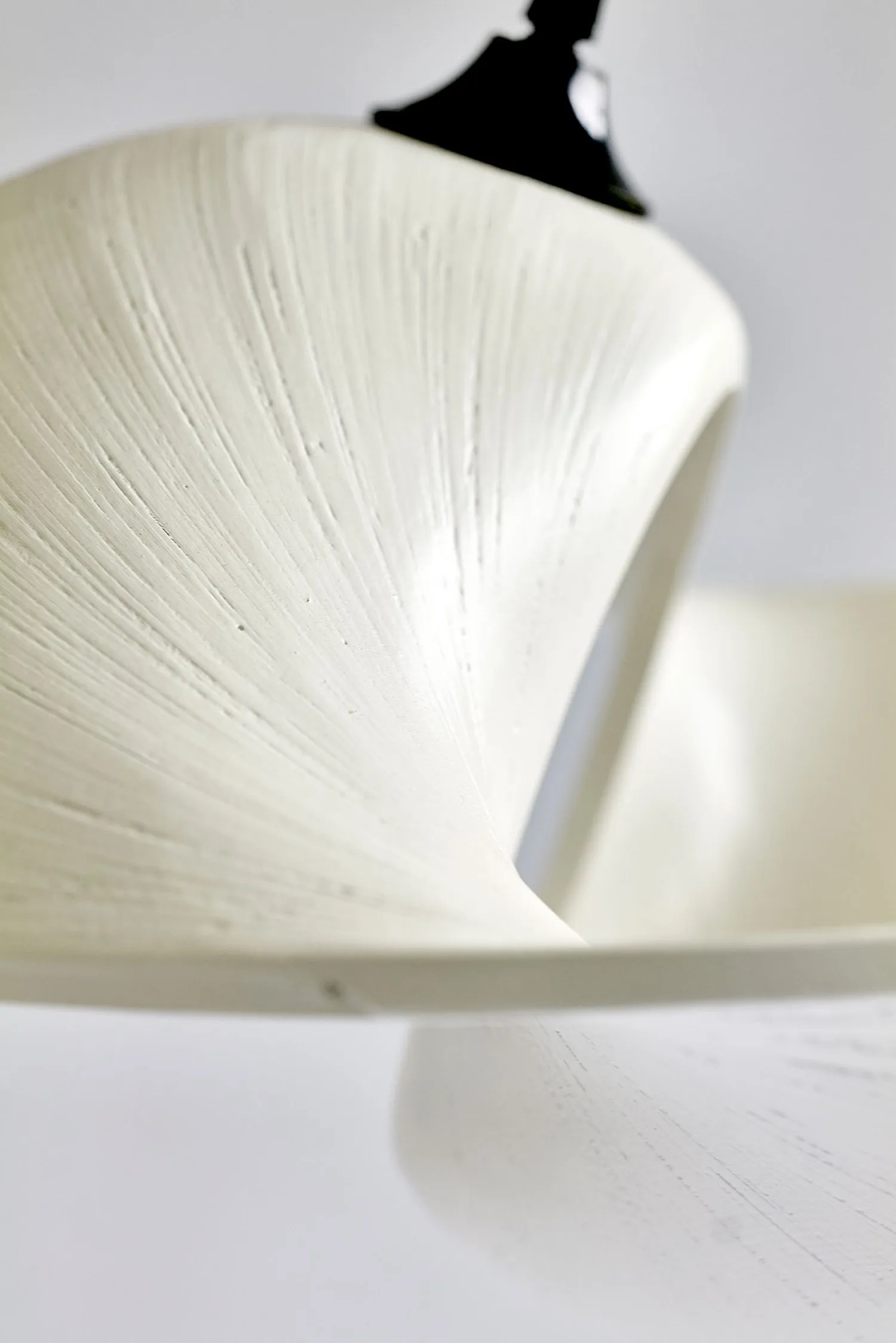 Close-up of the white Valbonne Air light showing its textured surface and twisted shape.