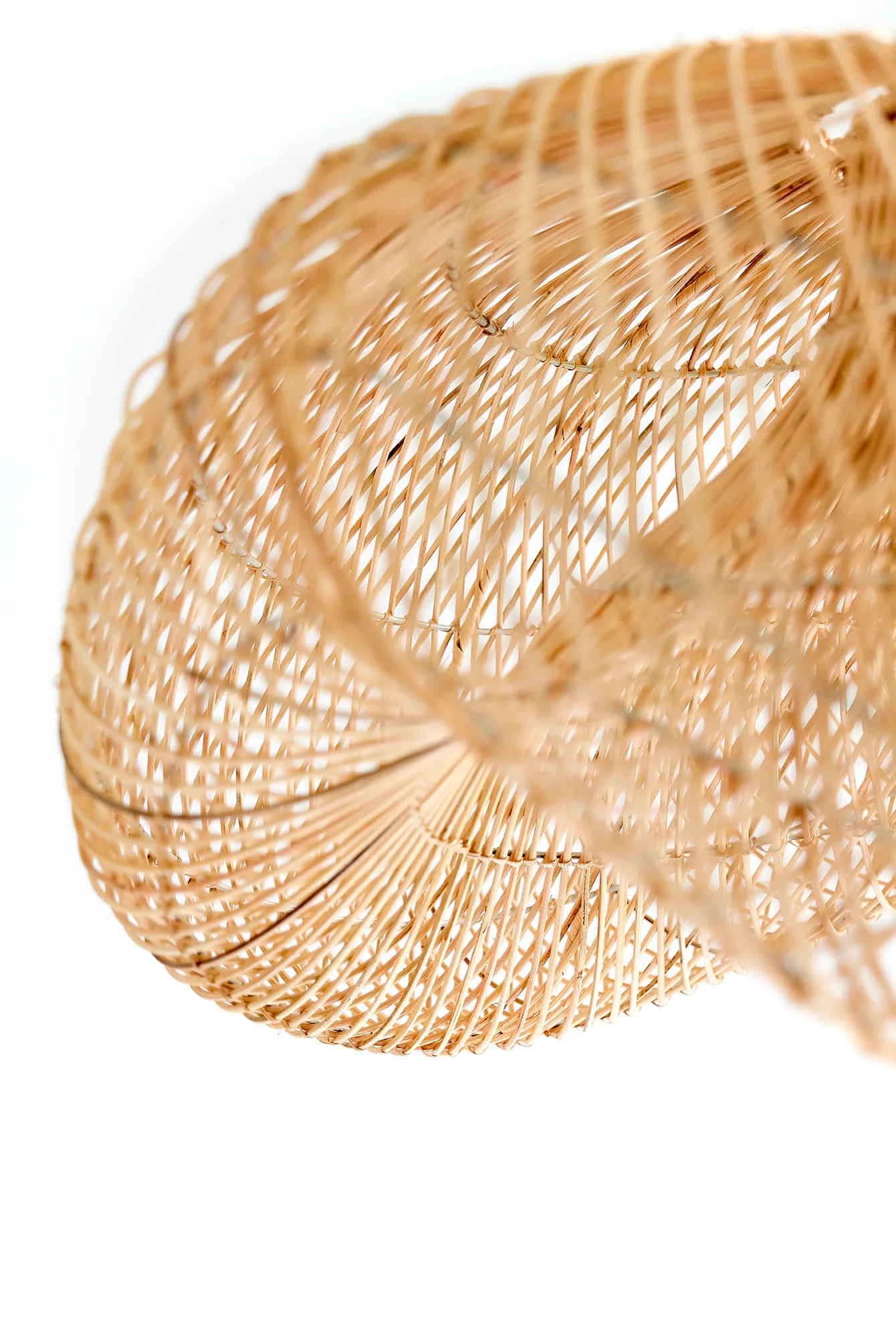 Detailed close-up of woven bamboo strands forming a curved, open basket-like light fixture.