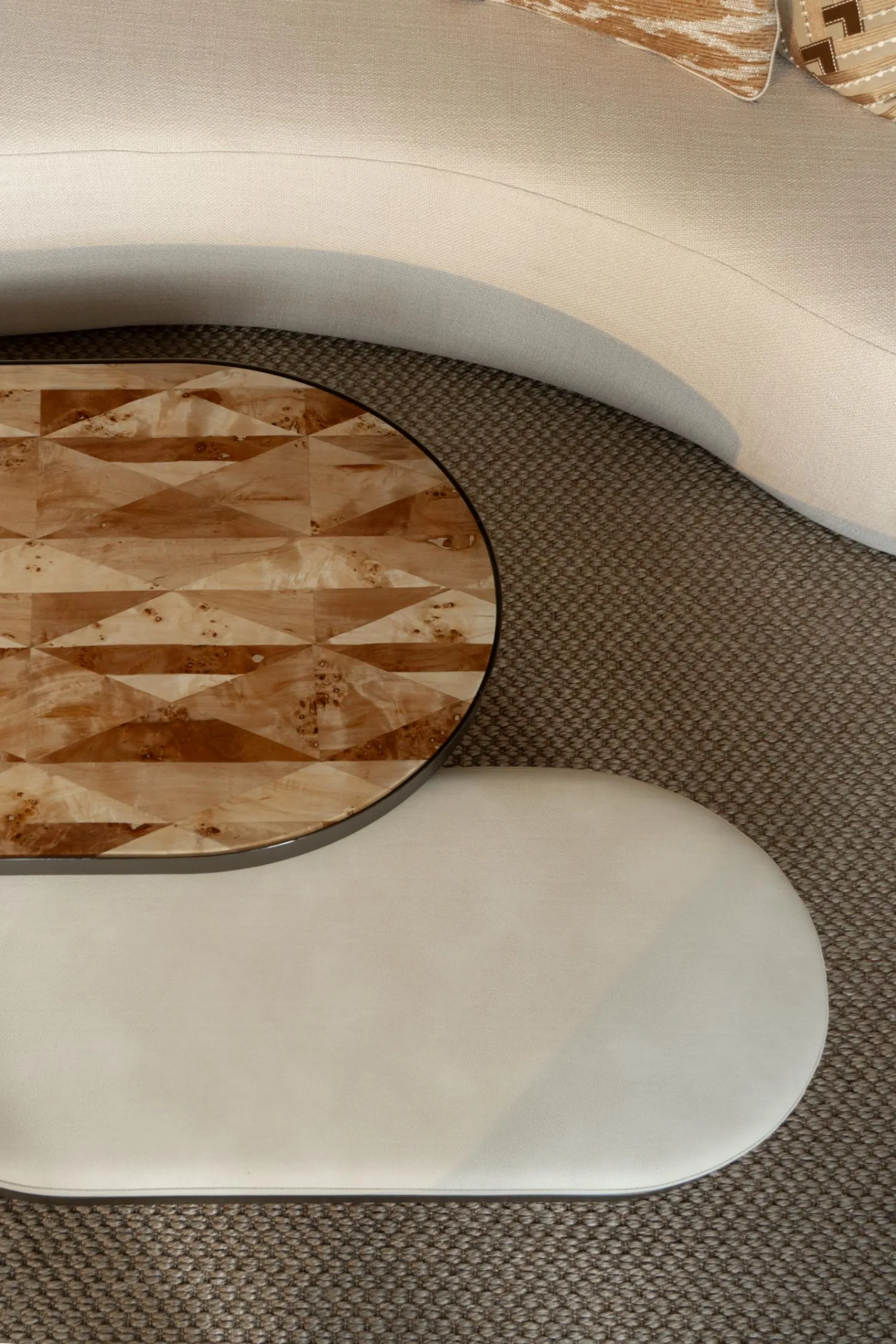Axel coffee table set viewed from above, paired with a curved cream sofa.