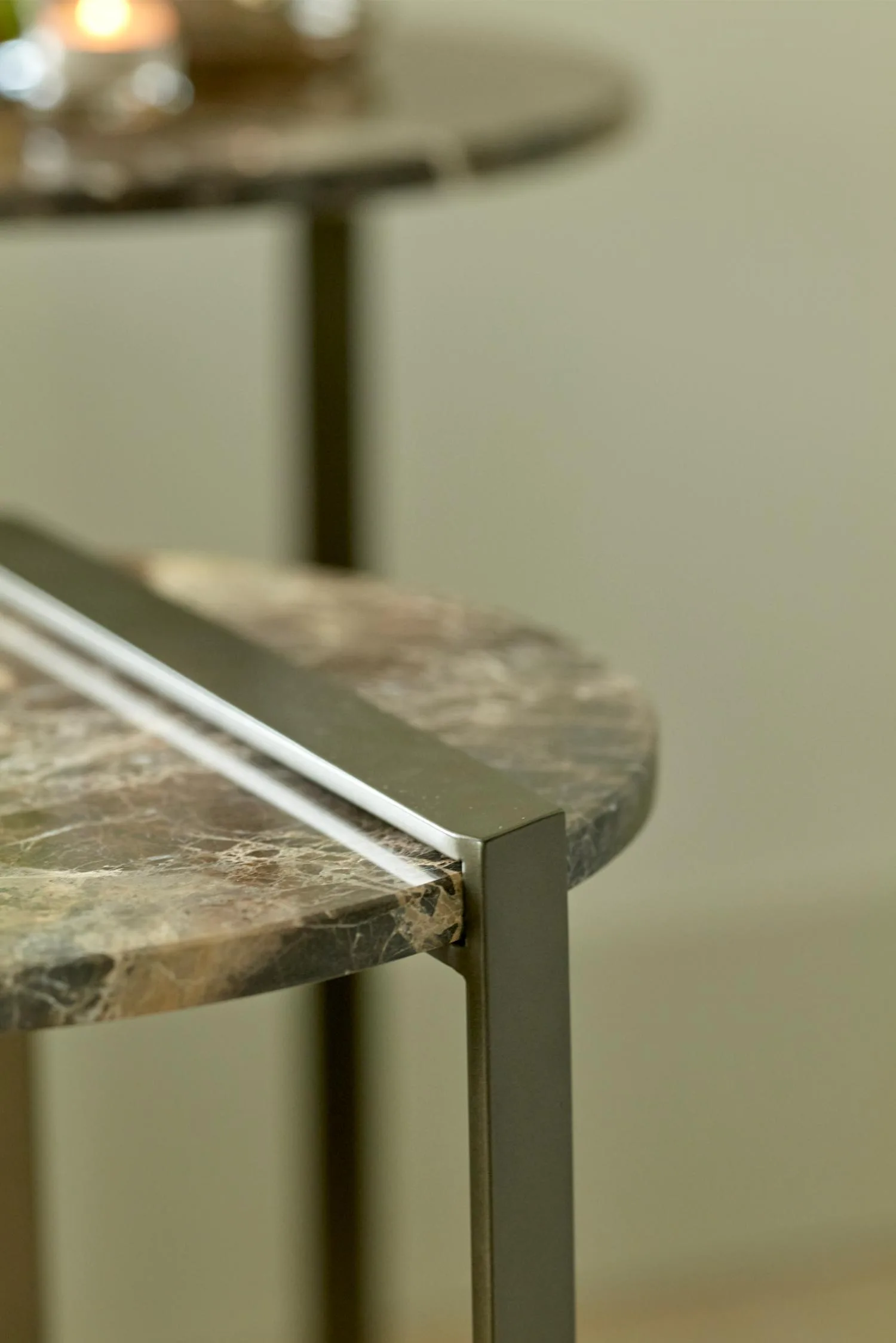 Close-up of the Butler side table with a brown marble top and metal frame.