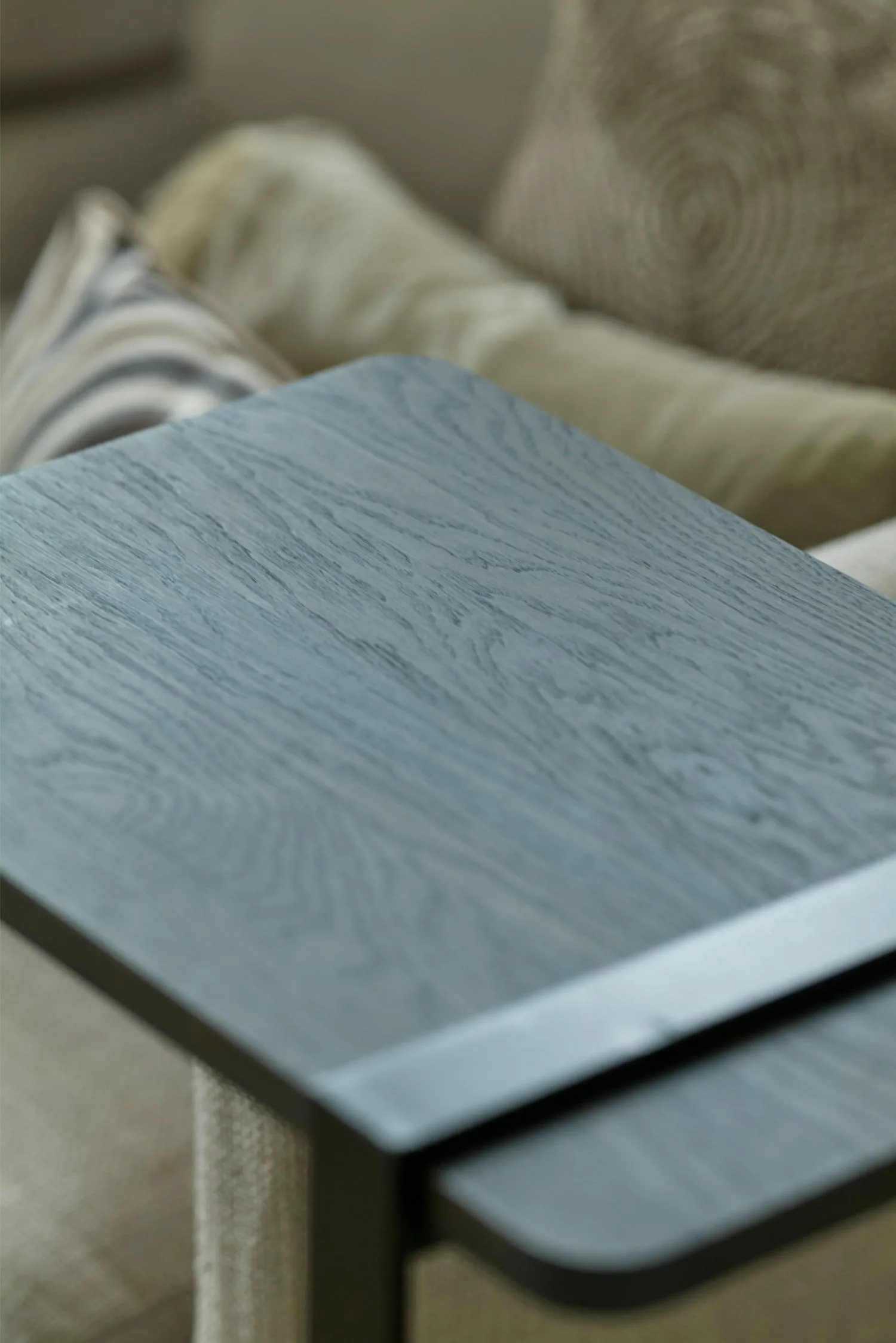 Close-up of the Butler side table with a rectangular dark wood top and black metal edge detail.