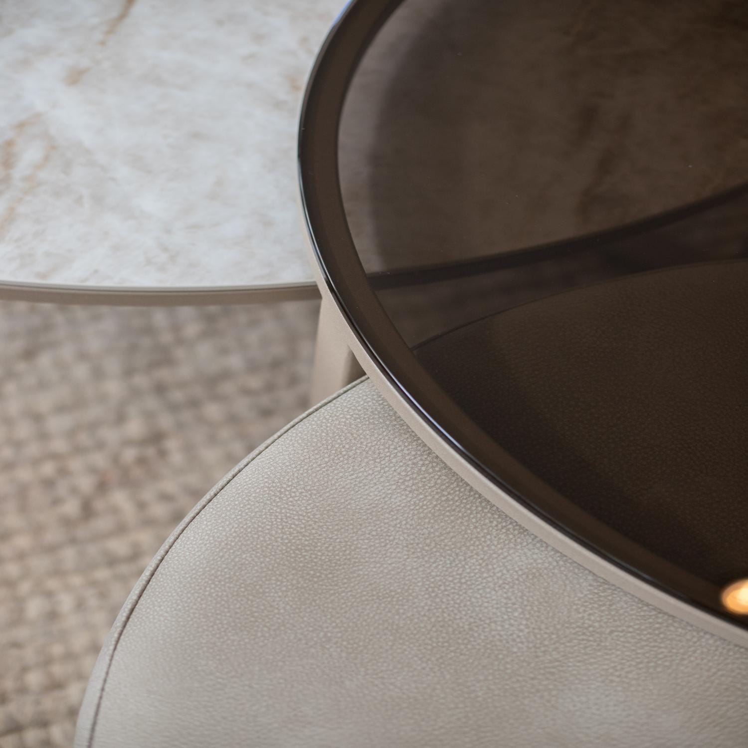 Close-up of round glass and stone tabletops with textured surfaces beneath.