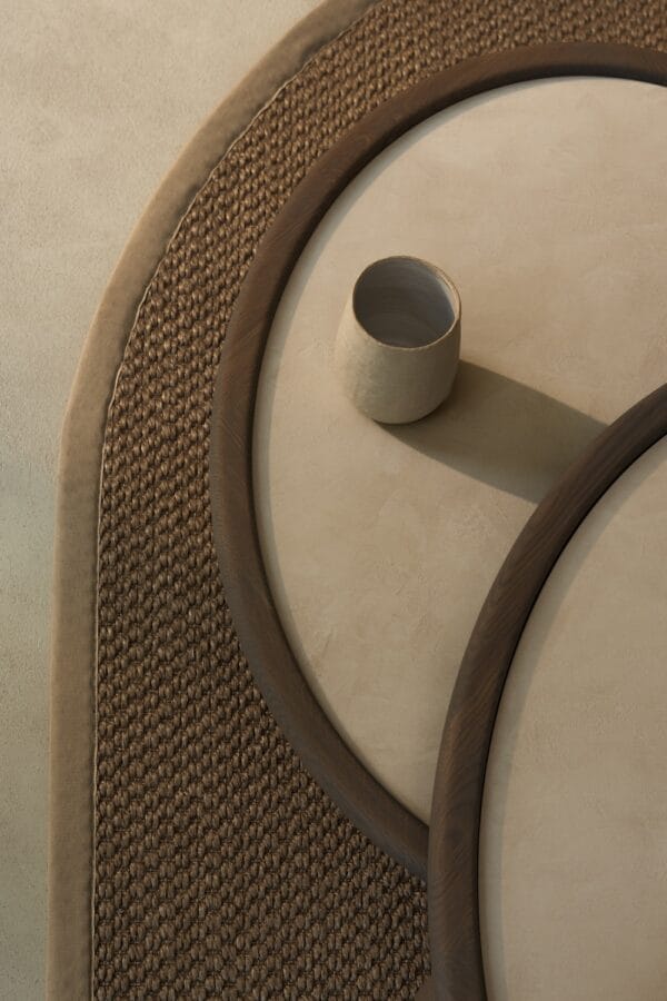 Side view of the Amalfi Coffee Tables, styled with a tall white vase and decorative bowl, on a natural woven rug.