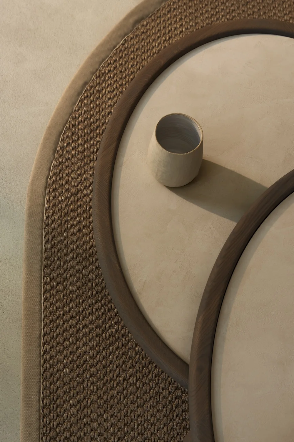 Top view of Amalfi Coffee Tables with round beige tops and dark wooden edges, styled with ceramic accessories on a woven rug.