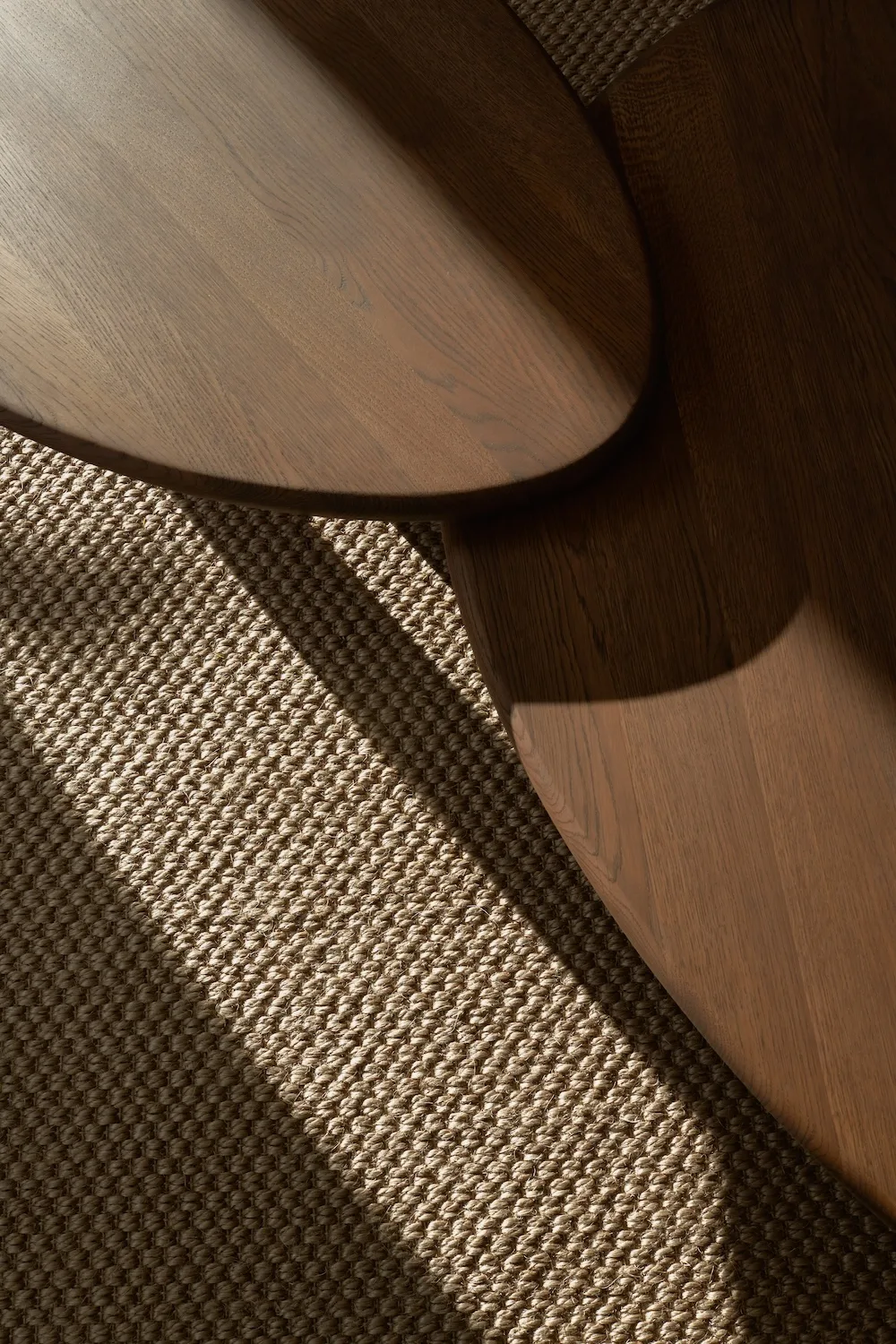 Top view of overlapping oak Como Coffee Tables with rich grain detail and soft morning light on a woven rug.