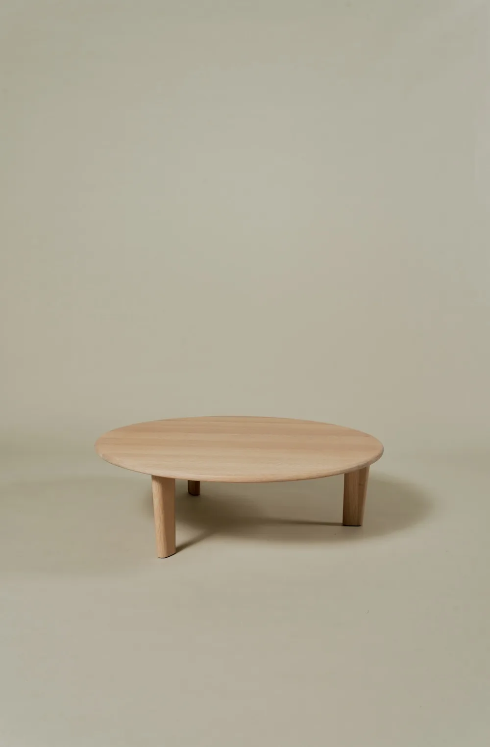 Miller Coffee Table in solid oak with a round wooden top and three legs.
