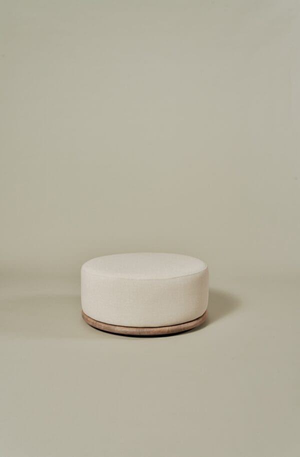Miller Coffee Table Set pouf with round beige upholstery and wooden base.