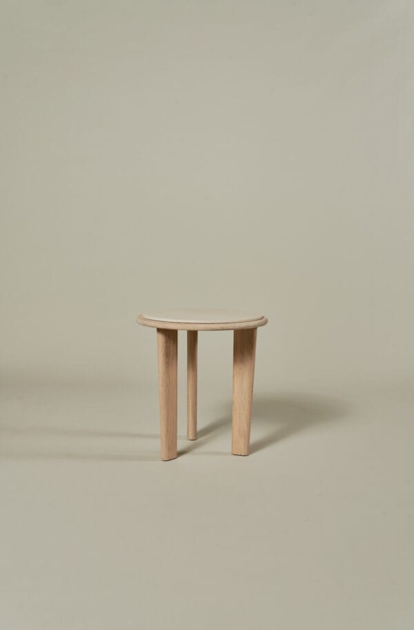 Small Miller Coffee Table with round travertine top and three light wooden legs.